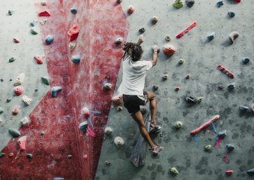 Man is on his way up on the climbing wall